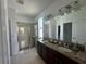 Bathroom with double vanity with granite countertops, glass-enclosed shower, and linen closet at 12032 Grand Kempston Dr, Gibsonton, FL 33534