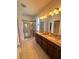 Bright bathroom featuring a double vanity, granite countertops, and glass-enclosed shower at 12032 Grand Kempston Dr, Gibsonton, FL 33534