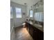 Bathroom features a granite double-sink vanity and wood-look tile flooring at 12032 Grand Kempston Dr, Gibsonton, FL 33534