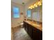 Bathroom features a granite double-sink vanity and wood-look tile flooring at 12032 Grand Kempston Dr, Gibsonton, FL 33534