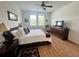 Bedroom with hardwood floors, ceiling fan, windows, and queen-sized bed at 12032 Grand Kempston Dr, Gibsonton, FL 33534