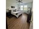 Bright bedroom features a ceiling fan, two windows, and wood-look flooring at 12032 Grand Kempston Dr, Gibsonton, FL 33534