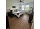 Bright bedroom features a ceiling fan, two windows, and wood-look flooring at 12032 Grand Kempston Dr, Gibsonton, FL 33534