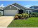 Charming single-story home featuring a well-manicured lawn, beautiful landscaping and attached two-car garage at 12032 Grand Kempston Dr, Gibsonton, FL 33534
