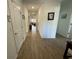 Hallway showcasing wood-style tile flooring and several interior doors and wall art at 12032 Grand Kempston Dr, Gibsonton, FL 33534