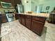 Kitchen with island, granite countertops, wood-look tile floor and stainless steel appliances at 12032 Grand Kempston Dr, Gibsonton, FL 33534