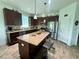 Well-equipped kitchen with granite countertops, stainless steel appliances, dark wood cabinets and center island at 12032 Grand Kempston Dr, Gibsonton, FL 33534