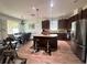 Open-concept kitchen and dining area, featuring dark wood cabinets, granite countertops, and stainless steel appliances at 12032 Grand Kempston Dr, Gibsonton, FL 33534