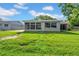 Lush backyard featuring a well-kept lawn, fence, and partially screened-in back of house at 12401 Yorktown Ln, Bayonet Point, FL 34667