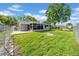 Spacious backyard with a well-maintained lawn, fence, and screened-in lanai at 12401 Yorktown Ln, Bayonet Point, FL 34667
