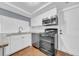 Well-lit kitchen with white cabinets, stainless steel microwave, oven, and dishwasher at 12401 Yorktown Ln, Bayonet Point, FL 34667