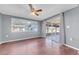 Bright living room with wood floors, a ceiling fan, and sliding doors to the lanai at 12401 Yorktown Ln, Bayonet Point, FL 34667