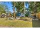 Backyard with a blue home, gravel fire pit area and fencing offering plenty of space for outdoor activities at 1302 E Flora St, Tampa, FL 33604