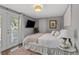 Bright bedroom featuring a queen bed, wood floors, white walls, and a glass door to the outside at 1302 E Flora St, Tampa, FL 33604