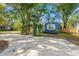 Blue home with a circular driveway, vine-covered pergola, and a charming exterior, perfect for curb appeal at 1302 E Flora St, Tampa, FL 33604
