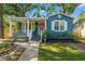 Charming blue single-story home featuring a cozy front porch, landscaped yard, and a quaint walkway at 1302 E Flora St, Tampa, FL 33604