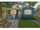 Charming blue home with a cozy front porch, complemented by a manicured lawn and mature landscaping at 1302 E Flora St, Tampa, FL 33604