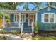 Beautiful blue house showcasing front porch, a landscaped yard, and an inviting walkway leading to the entrance at 1302 E Flora St, Tampa, FL 33604