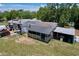 A full aerial view showcasing the rear of the home with a covered porch and surrounding property with various outbuildings at 13341 Hexam Rd, Weeki Wachee, FL 34613