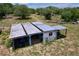 Image of an old barn surrounded by vegetation and with various items stored under the covered area at 13341 Hexam Rd, Weeki Wachee, FL 34613