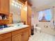 Bright bathroom featuring a wood vanity with sink, toilet, and window at 13341 Hexam Rd, Weeki Wachee, FL 34613