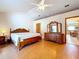 Spacious bedroom features a wooden frame bed and dresser with views to dining area at 13341 Hexam Rd, Weeki Wachee, FL 34613