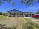 Charming home exterior with stone accents, covered porch, carport, and lush front yard at 13341 Hexam Rd, Weeki Wachee, FL 34613