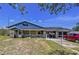 Exterior shot of home featuring a screened-in porch, unique facade design, and treed front yard at 13341 Hexam Rd, Weeki Wachee, FL 34613