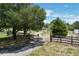 The home is accessed by a gated driveway surrounded by trees and a fenced perimeter at 13341 Hexam Rd, Weeki Wachee, FL 34613