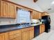 Traditional kitchen with wood cabinets, stainless steel sink, black appliances and granite countertops at 13341 Hexam Rd, Weeki Wachee, FL 34613