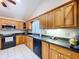 Traditional kitchen with wood cabinets, black appliances, and white tiled floor at 13341 Hexam Rd, Weeki Wachee, FL 34613