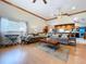 Bright living room boasts wood floors, large windows, and open layout to the kitchen at 13341 Hexam Rd, Weeki Wachee, FL 34613
