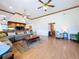 Spacious living room featuring wood floors, ceiling fans and comfortable seating with kitchen view at 13341 Hexam Rd, Weeki Wachee, FL 34613