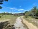 A gravel driveway leads to a house on a large lot with mature trees and a well-maintained lawn at 13341 Hexam Rd, Weeki Wachee, FL 34613