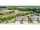 An aerial view capturing a block of townhomes with mature trees nearby and a pond at 1396 White Fox Run, Lutz, FL 33549