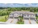 An aerial view showcasing a block of townhomes nestled against a lush green space at 1396 White Fox Run, Lutz, FL 33549