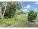Lush backyard featuring pond and lots of trees, with view of other houses at 1396 White Fox Run, Lutz, FL 33549