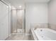 Bright bathroom features a glass shower and soaking tub with tile surround at 1396 White Fox Run, Lutz, FL 33549
