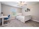 Well-lit bedroom with carpet, ceiling fan, bed, desk and a chair at 1396 White Fox Run, Lutz, FL 33549