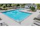 Community pool with lounge chairs and umbrellas for relaxing poolside at 1396 White Fox Run, Lutz, FL 33549