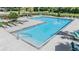 Community pool with lounge chairs, umbrellas, and a shallow entry at 1396 White Fox Run, Lutz, FL 33549