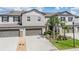 Charming two-story townhome featuring attached garages and beautifully landscaped front yard at 1396 White Fox Run, Lutz, FL 33549