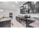 This kitchen features black cabinets, stainless steel appliances, and granite countertops at 1396 White Fox Run, Lutz, FL 33549