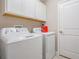 Laundry room with white washer and dryer and white cabinets at 1396 White Fox Run, Lutz, FL 33549