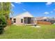Landscaped backyard featuring a screen-enclosed patio at 14612 Corkwood Dr, Tampa, FL 33626