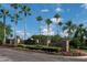 Westwood Lakes community entrance with a stone wall, flowers, manicured bushes, and palm trees at 14612 Corkwood Dr, Tampa, FL 33626