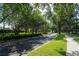 Paved community road lined with mature trees and sidewalks on a sunny day at 14612 Corkwood Dr, Tampa, FL 33626