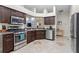 Modern kitchen features stainless steel appliances, dark wood cabinetry, and stylish tile flooring at 14612 Corkwood Dr, Tampa, FL 33626