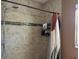 Shower featuring detailed tile, dark hardware, a glass shower door, and storage for bath products at 1462 Highfield Dr, Clearwater, FL 33764