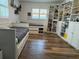 Spacious bedroom with wood floors, two beds, shelving, and bright natural light from the windows at 1462 Highfield Dr, Clearwater, FL 33764